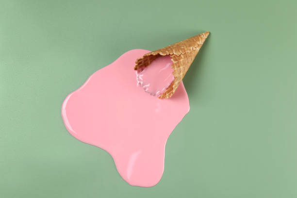 istock Melted ice cream and wafer cone on green background, top view 1940486368