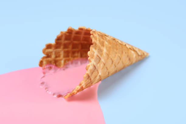 istock Melted ice cream and wafer cone on light blue background, closeup 1940486378