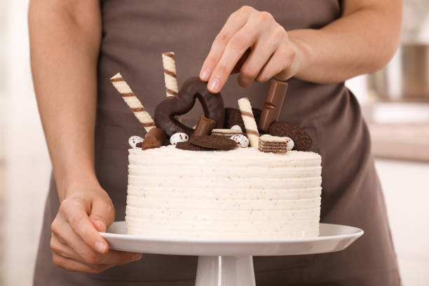 istock Woman decorating delicious cake with sweets, closeup 1940487461