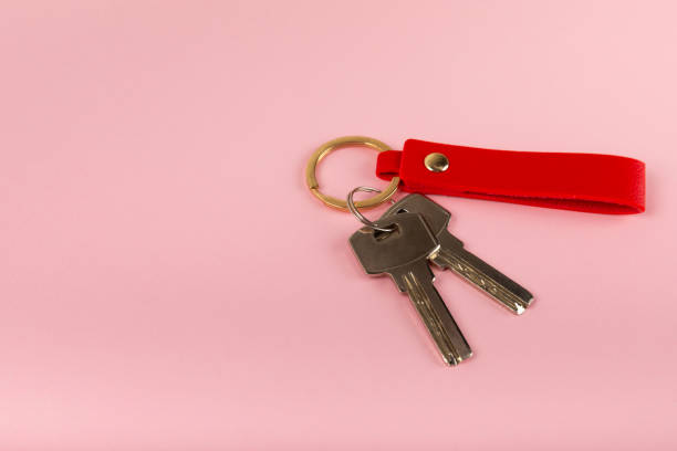istock Keychain with key ring isolated on a colored background. Concepts for real estate and moving home or renting property. Buying a property. Mock-up keychain.Copy space. 1940534896