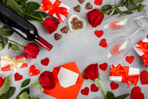 Valentine's Day concept. Valentine's Day background. Gifts, candles, confetti, envelope - postcard on background. Flatley, top view, copy space.Valentine's day celebration