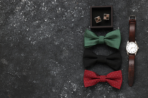 Flat lay composition with stylish color bow ties on grey background. Space for text