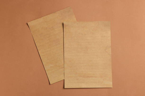 istock Sheets of old parchment paper on brown background, flat lay 1940588456
