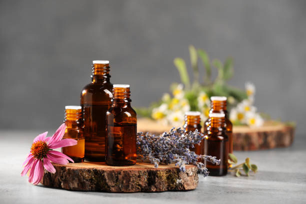 istock Bottles with essential oils and flowers on light table. Space for text 1940594443
