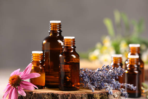 istock Bottles with essential oils and flowers on blurred background, closeup 1940594998