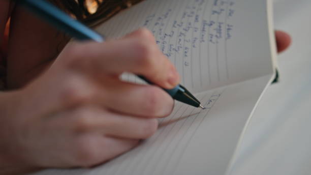 istock Hands making diary notes closeup. Happy smiling girl holding pen writing plans 1940598228