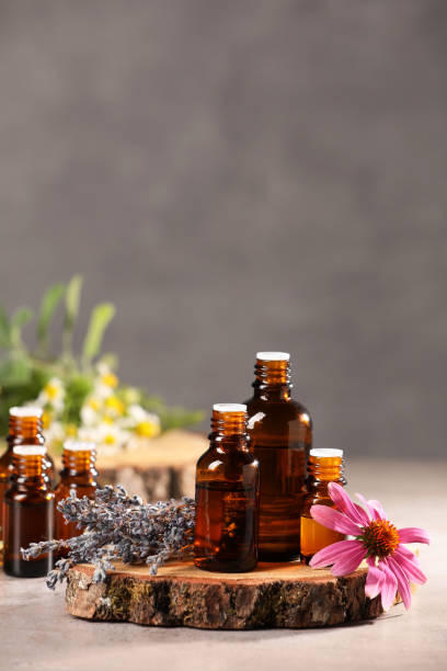 istock Bottles with essential oils and flowers on light table. Space for text 1940599279