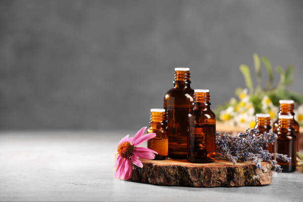 istock Bottles with essential oils and flowers on light table. Space for text 1940600896