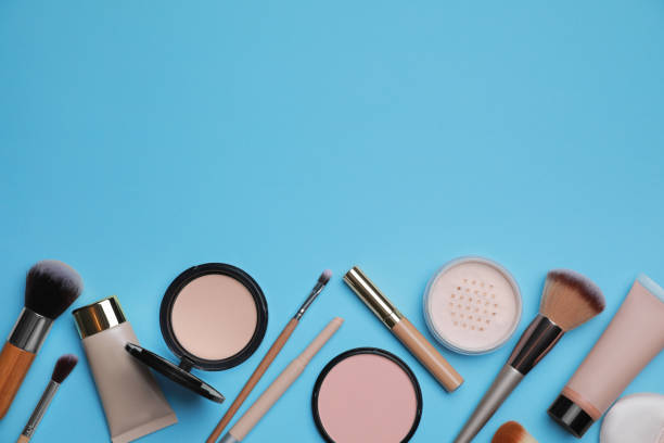 istock Face powders and other decorative cosmetic products on light blue background, flat lay. Space for text 1940612336