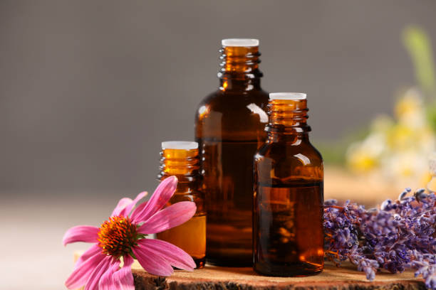 istock Bottles with essential oils and flowers on blurred background, closeup 1940616166