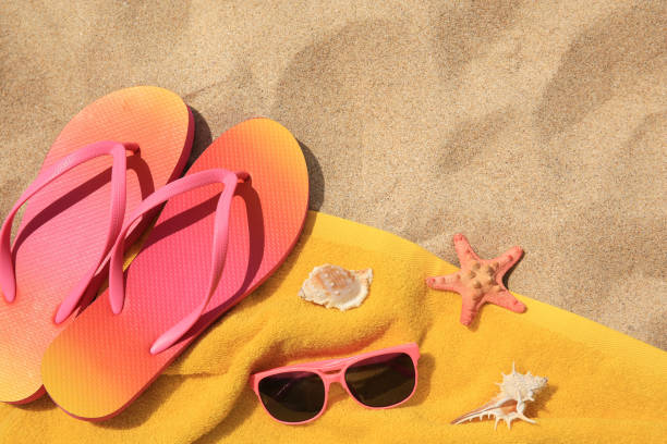 istock Flip flops and other beach items on sand, flat lay. Space for text 1940629084