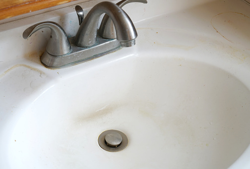 close up on dirty water sink and tap in bathroom