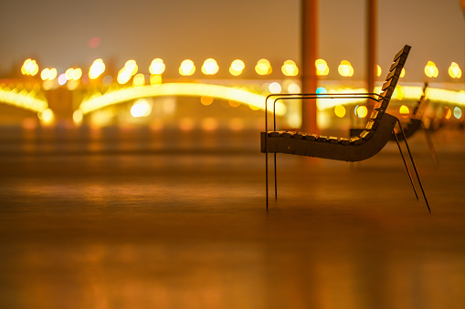 Flooded Danube river. Bench near parliament building. Margit bridge on the background.