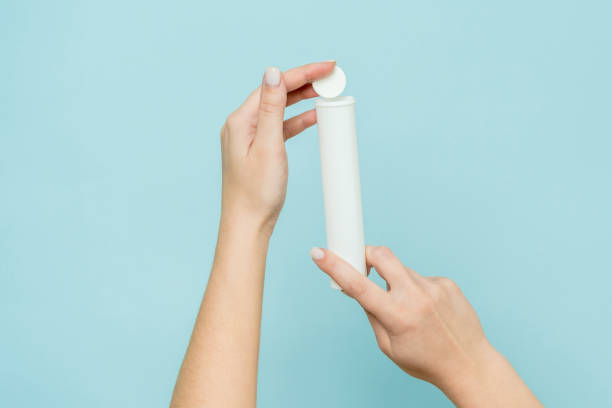 istock Packaging for vitamins, pills with tablet in hand. White tube. Mockup 1940650539