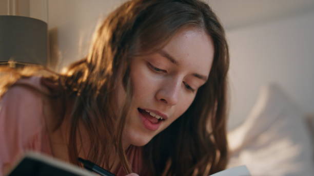 istock Closeup girl studying home writing notebook. Focused young woman making notes 1940668391