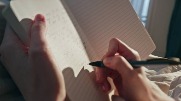 istock Female hands writing diary in sunlight closeup. Woman making notes in morning 1940672606