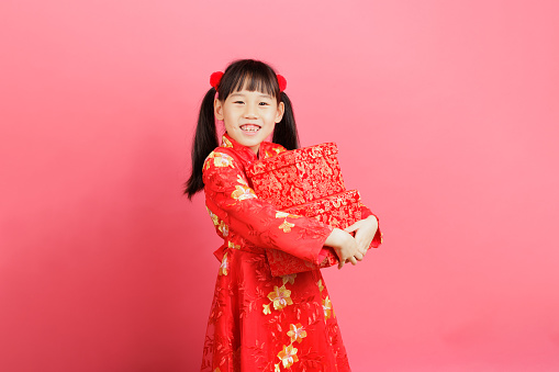 young Chinese girl celebrating Chinese new year against plain background