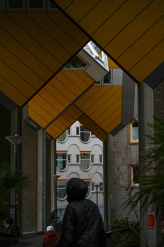 Overblaak 70, 3011 MH Rotterdam, Netherlands - December 26, 2023: Person between columns under Cube houses.