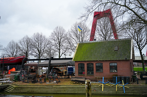 Koningsdam 1, 3011 TN Rotterdam, Netherlands - December 26, 2023: Scheepshelling Koningspoort building. Willemsbrug bridge on the background.