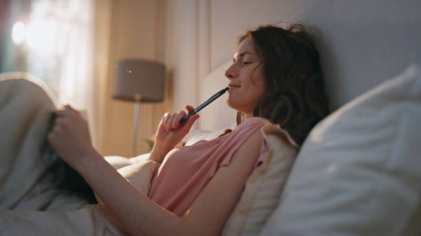 istock Smiling girl thinking ideas at home. Pensive calm woman making notes in diary 1940687028