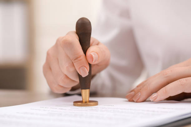 istock Woman stamping document at table, closeup view 1940696402