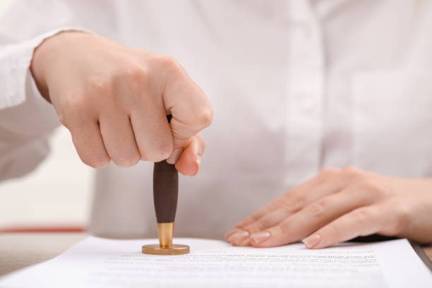 istock Woman stamping document at table, closeup view 1940696404