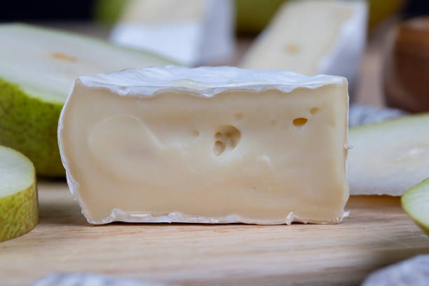 Camembert cheese on black plate with yellow pepper and parsley