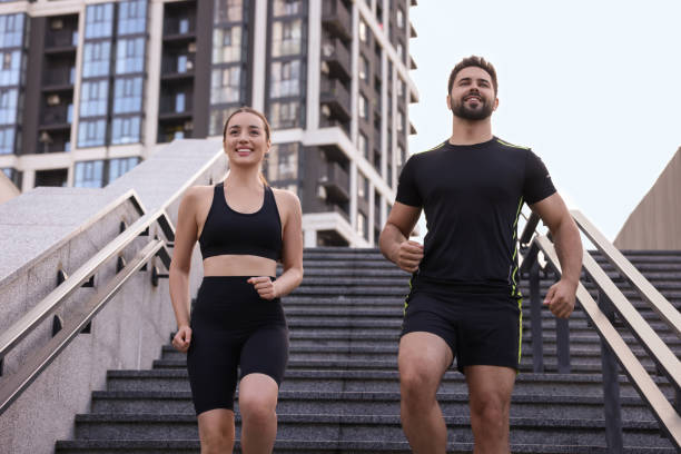 istock Healthy lifestyle. Happy couple running on steps outdoors, low angle view 1940721597