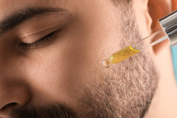 istock Handsome man applying cosmetic serum onto face, closeup 1940767014