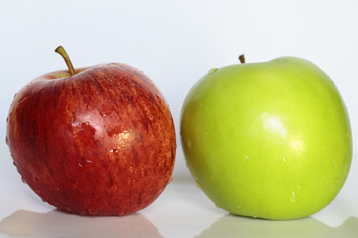 Two apples with water drops.  One red and one green.