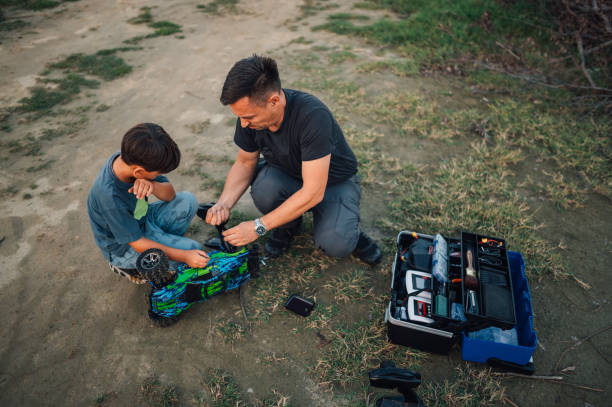 istock Father and son fixing remote control car with tools. Family fun. 1940792653