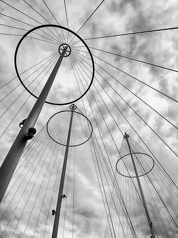 Copenhagen, Denmark - June  17, 2023: Olafur Eliasson designed the Circle Bridge or Cirkelbroen in Copenhagen with a series of circles, towers and cables that are outlined against a cloudy sky.