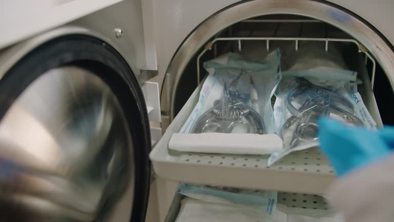 Woman taking out manicure tools from autoclave after sterilization