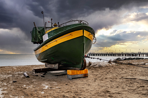 Old fishing boat on the sandy coast of the Baltic Sea