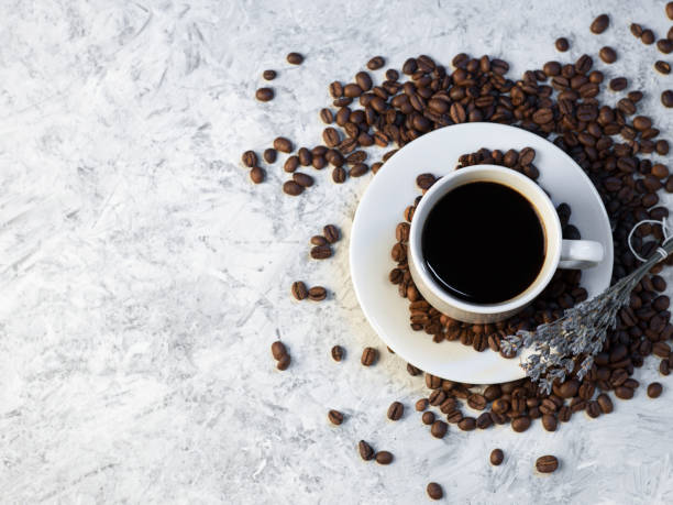 istock a cup of coffee on a stone white table, roasted coffee beans, top view copy space 1940869753