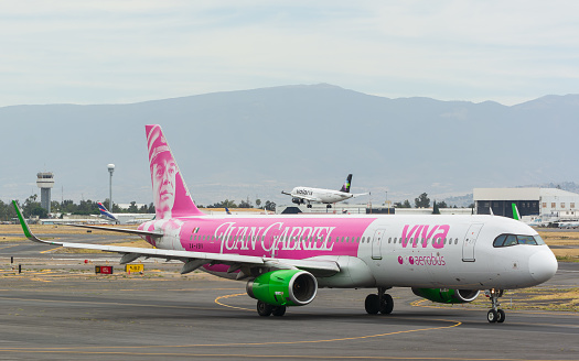 Ciudad de Mexico, Mexico – January 14, 2024: A pink white Viva aircraft taxiing on a sunny runway