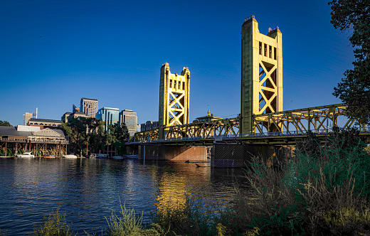 Photo of the golden Tower Bridge over the Sacramento River that connects West Sacramento to downtown Sacramento.