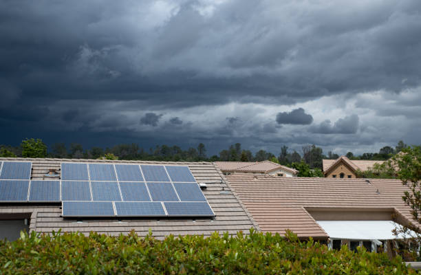 Suburban neighborhood with solar panels Solar panels appears on the roof of a suburban house with huge storm clouds in the sky. solar panels on the roof of building in a city stock pictures, royalty-free photos & images