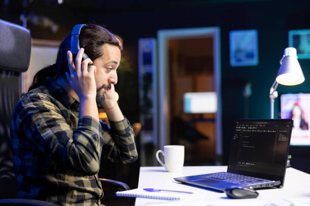 istock Man wears headphones and checks software 1941027106