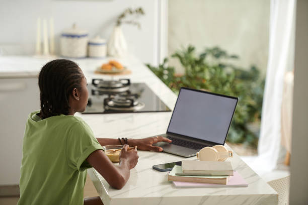 istock Girl Eating and Watching Entertaining Video 1941160322