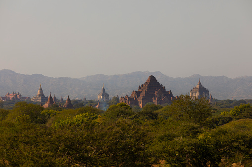 A landscape of mountains, temples and pagodas, immersed in the haze, dust and dry forest that surrounds them, in Bagan, Myanmar