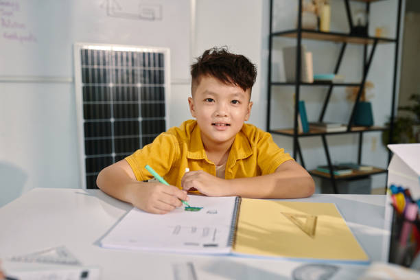 istock Boy Drawing Pictures in Copybook 1941171289