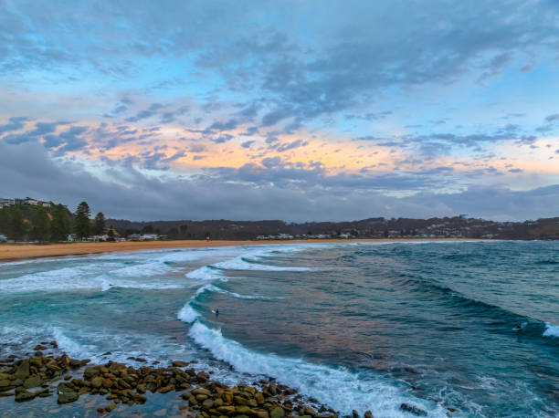 istock Summer Sunrise by the seaside with waves and clouds 1941195105