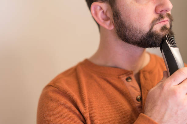 istock Man trims his beard with an electric trimmer. 1941220050