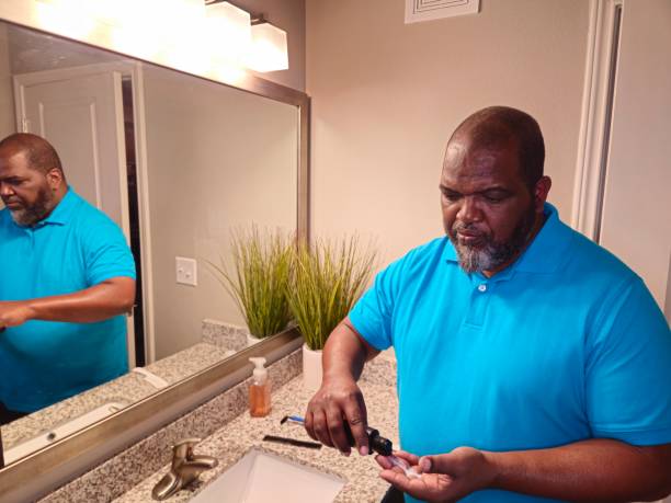 istock Black Male Squeezing Lotion Into Hand 1941259215