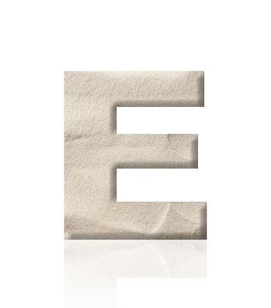 Close-up of three-dimensional sand alphabet letter E on white background.