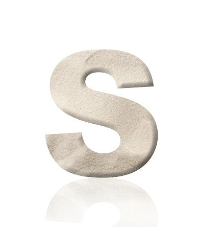 Close-up of three-dimensional sand alphabet letter S on white background.