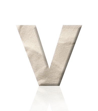 Close-up of three-dimensional sand alphabet letter V on white background.