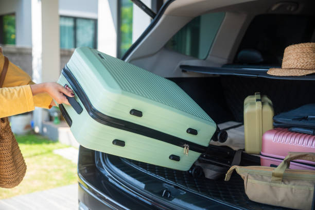 istock woman packing her suitcase into the car trunk 1941289446