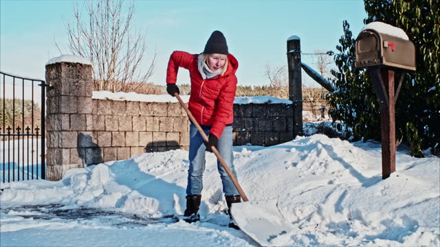 Woman using snow shovel